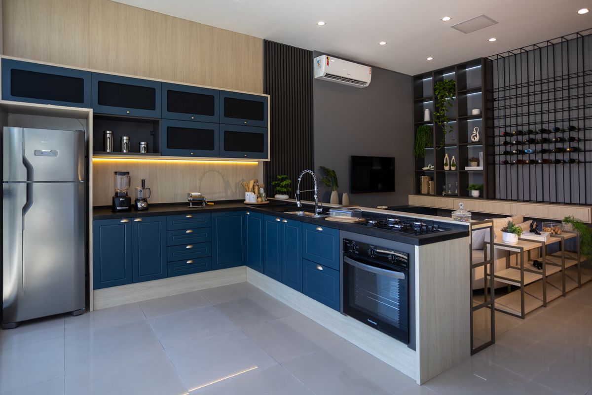 Cozinha planejada em tom azul, com ilha e eletrodomésticos integrados