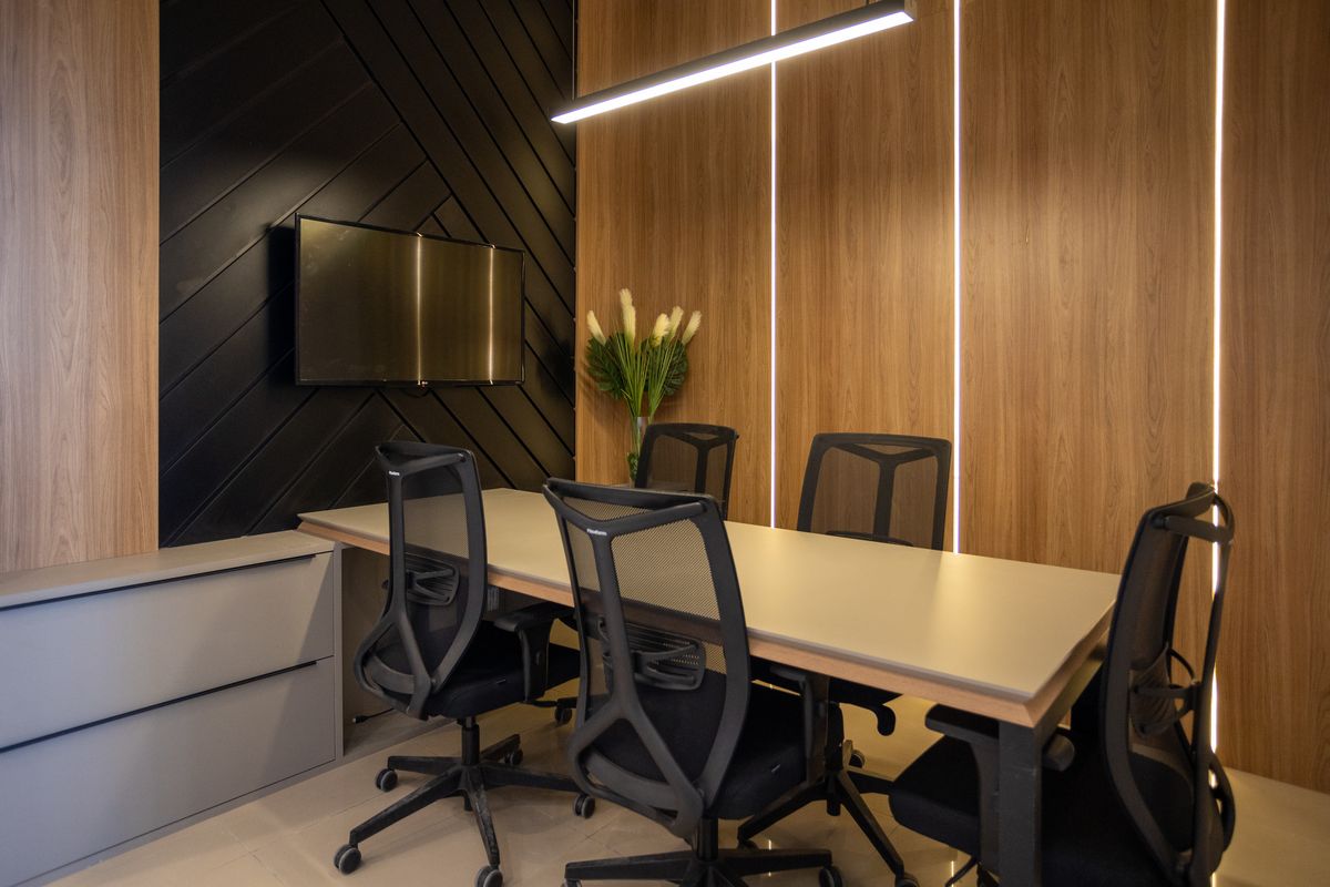 Sala de reunião planejada com mesa corporativa e painel ripado